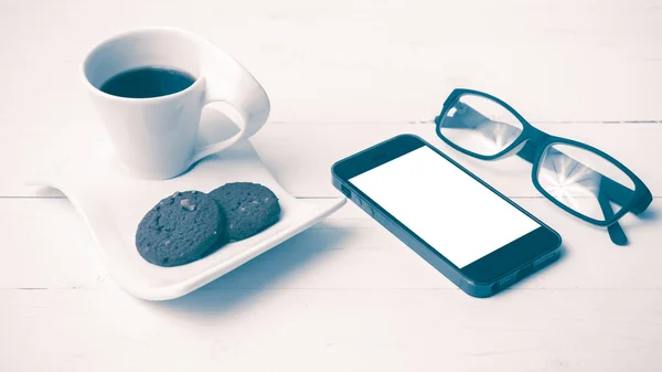 Xícara de café com biscoito, telefone e óculos estilo vintage — Fotografia de Stock