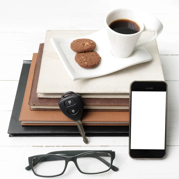 Taza de café con galletas, teléfono, pila de libro y llave del coche —  Fotos de Stock