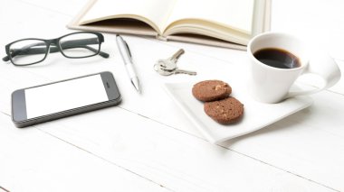 kahve fincanı ile tanımlama bilgisi, telefon, açık defter, anahtar ve gözlük