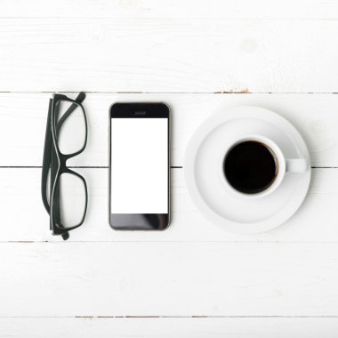 kahve fincanı ile telefon ve gözlük
