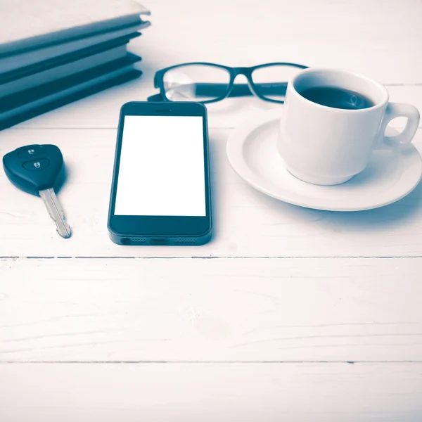 Kaffeetasse mit Telefon, Autoschlüssel, Brille und Bücherstapel — Stockfoto