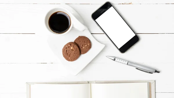Чашка кави з печивом, телефон з блокнотом і ручкою — стокове фото