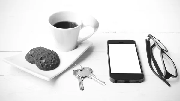 Taza de café con galletas, teléfono, anteojos y llave en blanco y negro — Foto de Stock