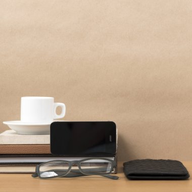 kahve, telefon, gözlük, kitap ve m-cüzdan yığını