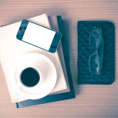 kahve, telefon, gözlük, kitap ve m-cüzdan yığını