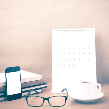 kahve, telefon, gözlük, kitap ve takvim yığını