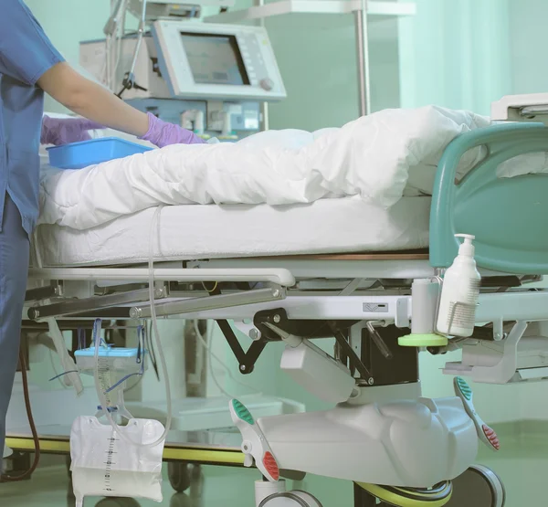 Enfermeira hospitalar à beira do leito dos pacientes em terapia intensiva — Fotografia de Stock
