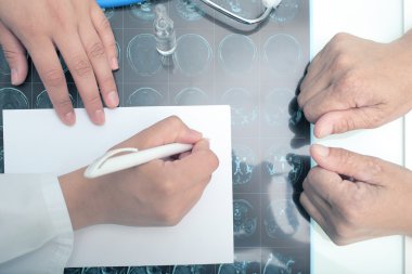 Doktor hastanın önünde tıbbi görüş yazma.