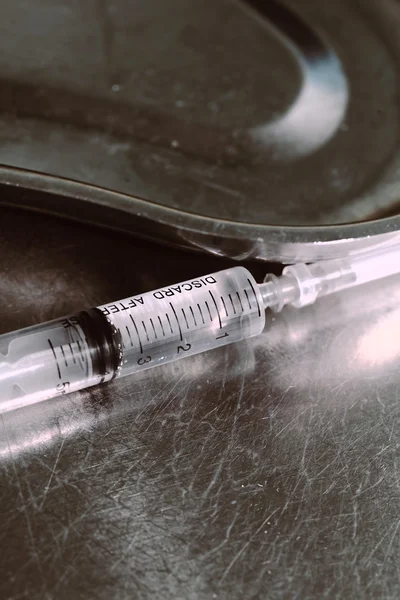 Syringe with a medicine in a steel tray — Stock Photo, Image