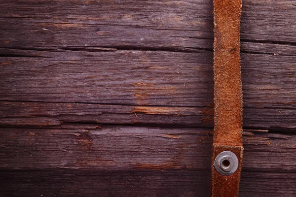 Tiras de cuero sobre un tablón de madera. El distintivo vaquero deta — Foto de Stock