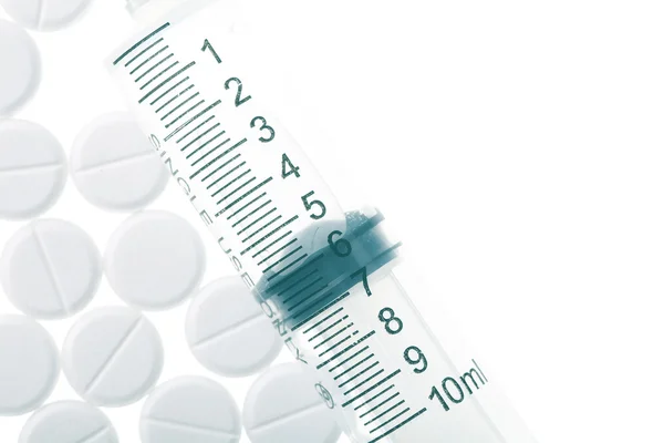 Siringe e comprimidos isolados no fundo branco — Fotografia de Stock