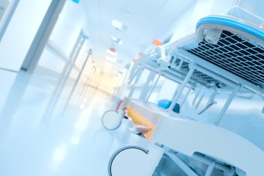 Işık parıltısı tarafından aydınlatılmış uzun bir koridorda sedye