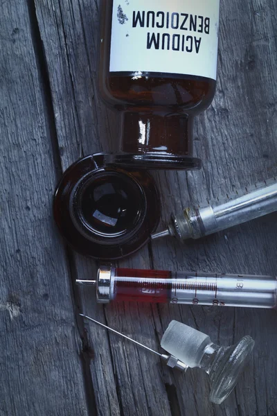 Ретро бутылка и шприцы на деревянном фоне — стоковое фото