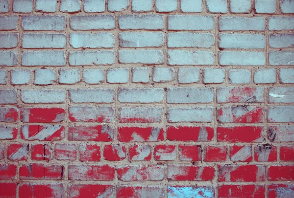 Ziegelwand mit roter Bemalung — Stockfoto