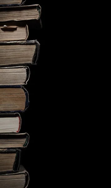 Alta pilha de livros antigos isolados em um fundo preto com espaco — Fotografia de Stock