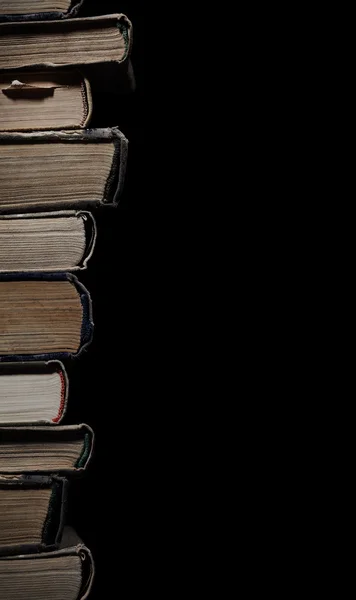 High stack of old books isolated on a black background with spac — Stock Photo, Image