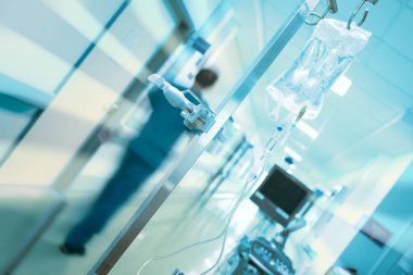 Kurtarma acil servisi kavramı. Tıbbi doktorun hareket figüründe bulanıklık, kutuptaki damar içi damlama ve hastane koridorundaki ultrasonik teşhis cihazı..