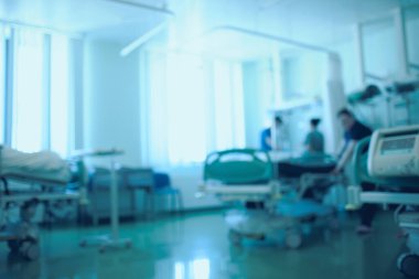 Working day in the intensive care unit. Group of medical workers doing their activities, unfocused background.