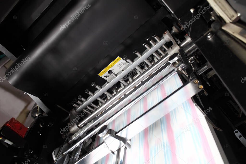 Printing press with blurry turning conveyor belt during work.