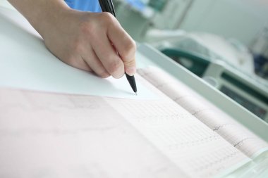 Doktor, yoğun bakımda yatan hastanın tıbbi geçmişiyle ilgili kayıtlar tutuyor..