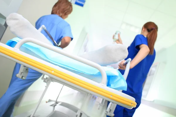 Paciente de urgencia con escolta médica en corredor hospitalario —  Fotos de Stock