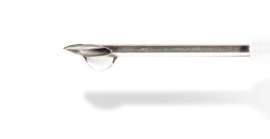 Shiny metal needle from the syringe with a drop of life-giving m clipart