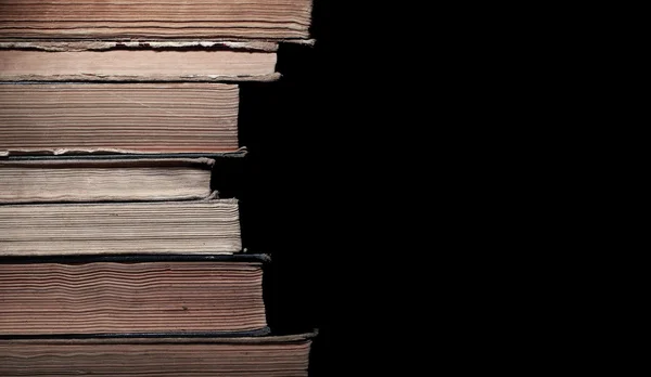 Stos starych książek odizolowanych na czarnym tle — Zdjęcie stockowe