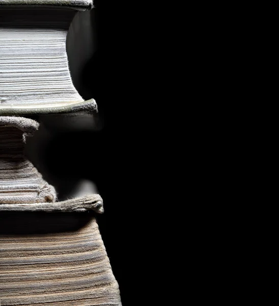 Oude boeken in stapel geïsoleerd op zwarte achtergrond — Stockfoto