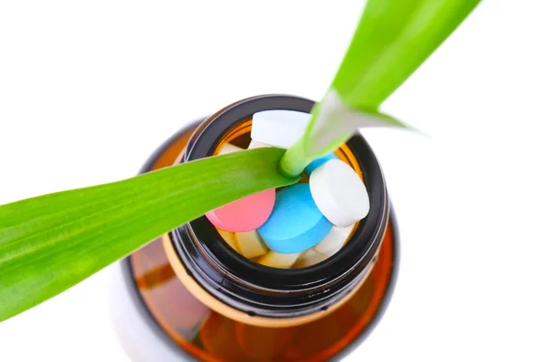 Green plant in bottle with pills — Stock Photo, Image