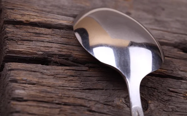 Metal spoon on old wooden table — Stock Photo, Image