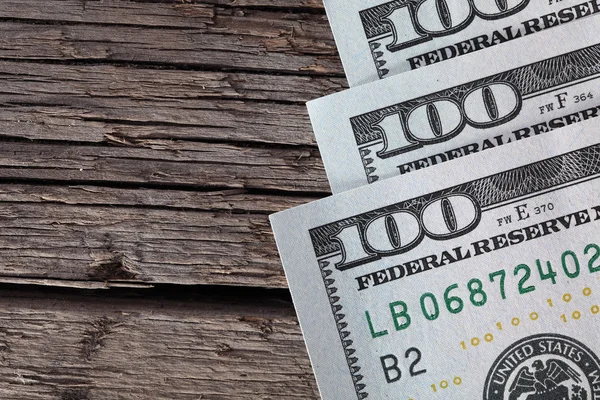 Dólares dinheiro em uma madeira áspera — Fotografia de Stock