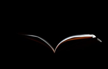 Open book illuminated by light in the dark clipart