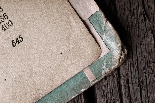 Open book with frayed cover on wooden texture — Stock Photo, Image