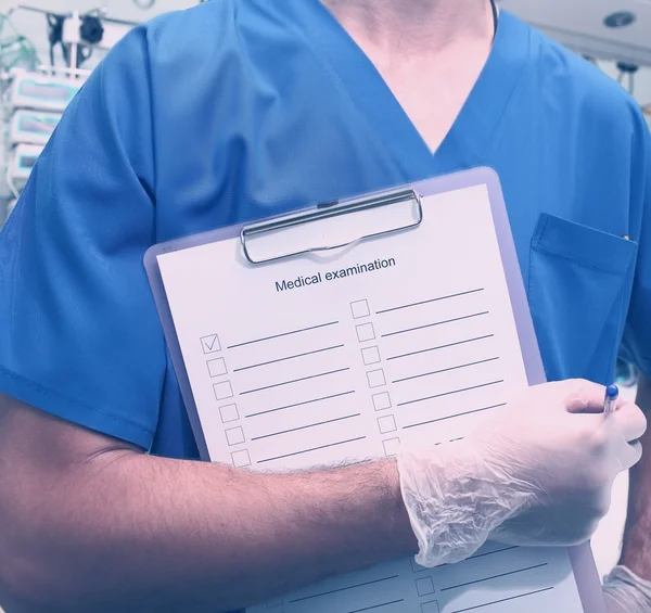 Medical worker whith clipboard in hospital room — Stock Photo, Image