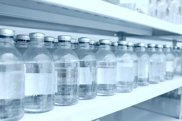 Medicine bottles in row on storage shelf — Stock Photo, Image