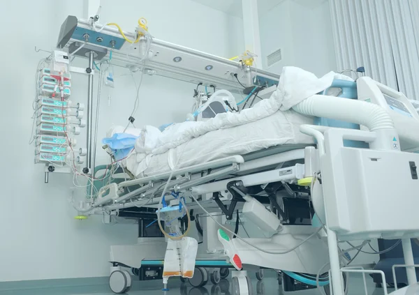 Bed in the intensive care with patient — Stock Photo, Image