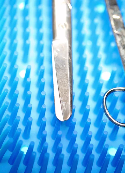 Ножницы на операционном столе с инструментами — стоковое фото