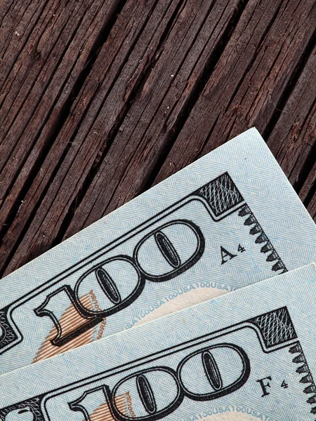 100 dolarové bankovky na dřevěné pozadí — Stock fotografie