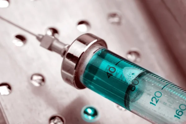 Vintage glass syringe with blue solution in a metal container — Stock Photo, Image