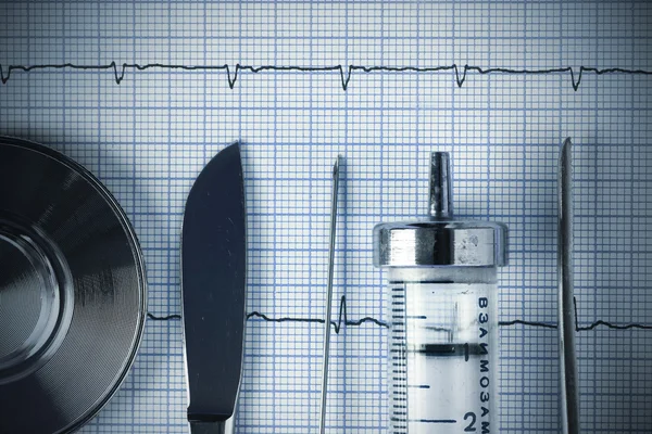 Vintage medical metal tools on the ECG graph — Stock Photo, Image