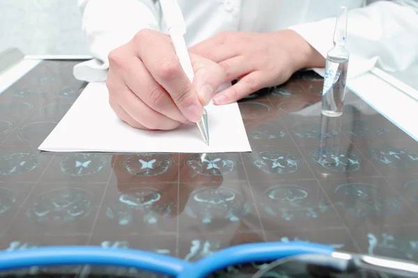 Arzt schrieb auf einen Tisch mit eingescanntem Rohling — Stockfoto