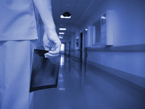 Доктор с рентгеновским снимком в пустом коридоре — стоковое фото