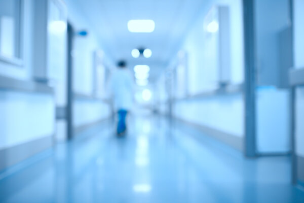 Силуэт врача в клиническом коридоре
