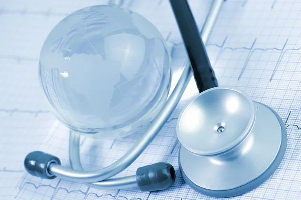 Stetoscopio e globo di vetro sullo sfondo dell'ECG — Foto Stock