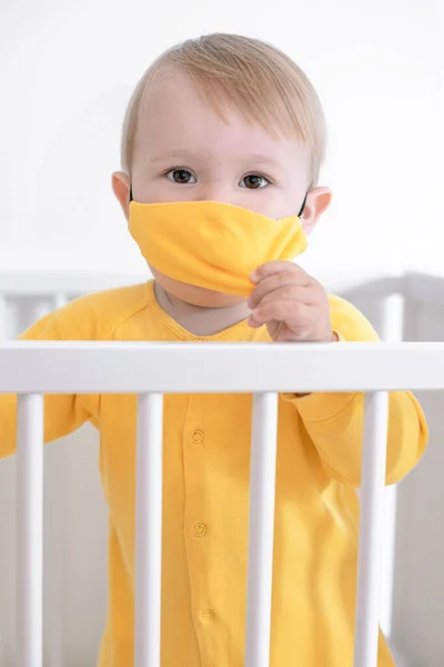 穿着黄色衣服的孩子戴着医疗面具 在隔离和自我隔离的过程中成长 这是一个新的现实 — 图库照片