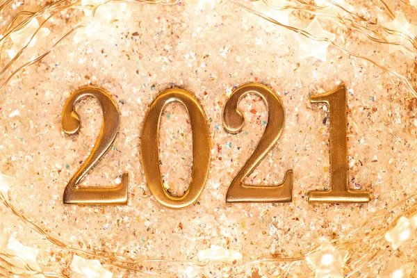 新年の背景コンフェッティと輝くガーランドの光沢のある背景に金の数字2021 幸せな新年カード — ストック写真
