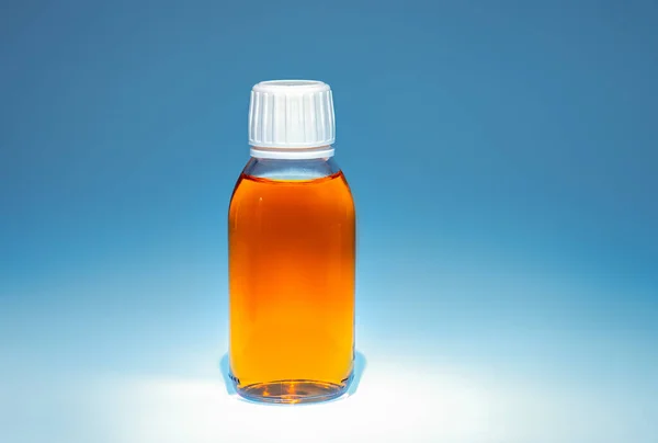 dark glass bottle with medicine, cough syrup, herbal tincture or medicine in a jar with white cap on a blue background, place for text, mock up for design