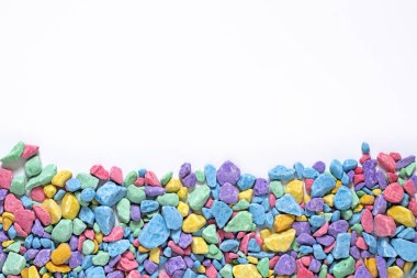 small multi-colored stones, colored soil, sprinkling, decorative stone chips, yellow, pink, blue mosaic pieces on a white background, place for text, mock up for design clipart