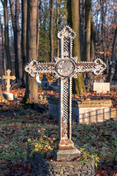 an old cross on a grave in an abandoned cemetery, an old unnamed burial in the autumn season