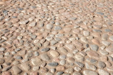 Yuvarlak kaldırım taşlarıyla döşenmiş eski bir cadde, eski kasabada bir yol veya bir meydan